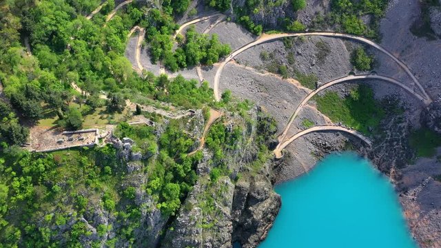 Aerial of a curvy trail coming from Imotski town leading to Blue Lake, a popular attraction in Croatia