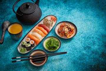 Fototapeta na wymiar Asian food assortment. Various sushi rolls placed on ceramic plates