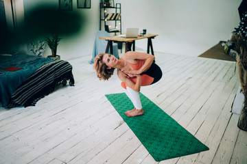 Focused sportswoman doing yoga on mat