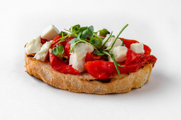 Tasty bruschetta with baked pepper, tomato and tofu. Easy cook, nutritious snack. Beautifully decorated catering banquet menu. Food snacks and appetizers for buffet. Isolated on white background.