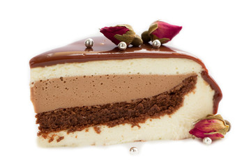 Piece of Triple chocolate  mousse cake decorated with gried rose flowers isolated on white