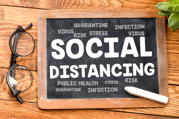 SOCIAL DISTANCING concept. The word social distancing written on a blackboard.