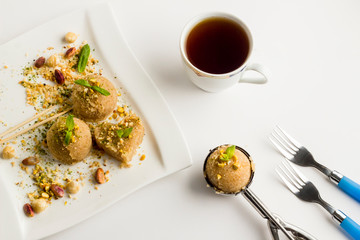 Classic Turkish Dessert,Semolina Halvah,served with a cup of tea on the white surface.Stylish design.