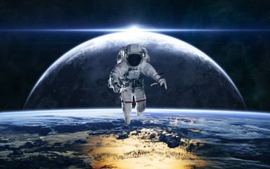 Astronaut on the background of planets in deep space. Star rise. Science fiction. Elements of this image furnished by NASA