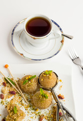 Classic Turkish Dessert,Semolina Halvah,served with a cup of tea on the white surface.Stylish design.