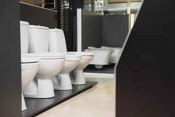 samples of modern sanitary ware for the toilet. new modern toilet in the plumbing store - obrazy, fototapety, plakaty