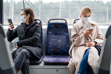 Young women using public transport with surgical mask