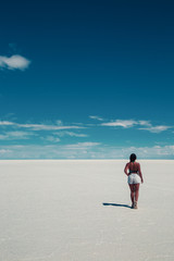beautiful woman from the back walking on a salt flat