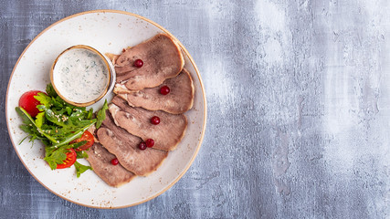 Delicious beef tongue with cranberry and white sauce. Copy space. Top view