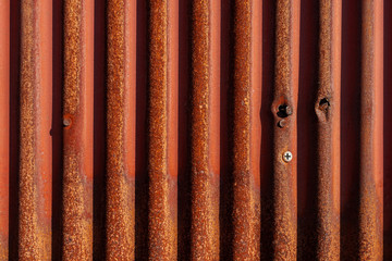 陽の当たる錆びた金属の外壁