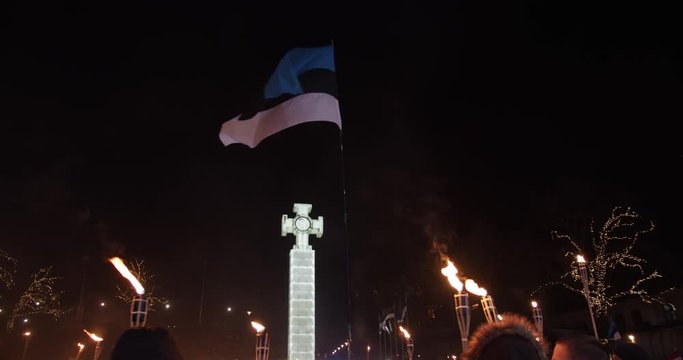 Torchlight procession with Estonian flag and freedom cross at night