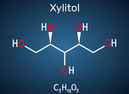 Xylitol,  C5H12O5 molecule. It is polyalcohol and sugar alcohol, an alditol. Is used as food additive E967 and sugar substitute.  Structural chemical formula on the dark blue background