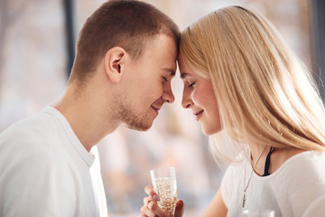 Young lovely couple together at home with champagne spending weekend and holidays together