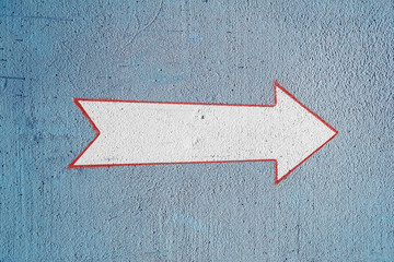 Arrow on the blue wall. A white arrow pointer is drawn on the plastered wall of the house....