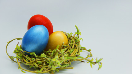 colorful Easter eggs in a nest of young willow branches