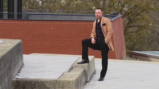 a man in a beige coat walks around the business center