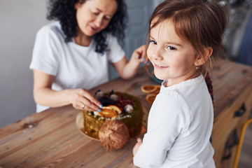 Senior woman with her granddaughter preparing dietical cake on kitchen