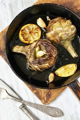 grilled artichoke with lemon in a pan.  Flatlay.  copy space. top view