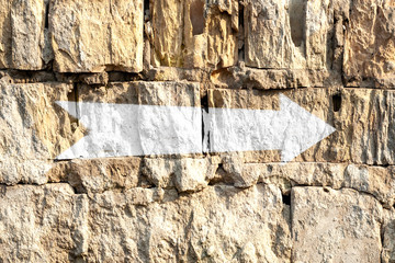 Arrow on a brick wall. White Pointer painted on an old brick wall of the house. Direction indicator. Signs on the street.