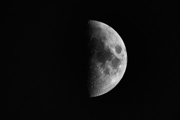 A black and white crescent moon in front of a black background without stars