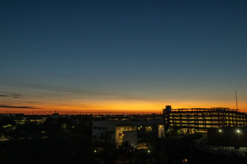 Night sky just after sunset as background over the city with a few lights on.