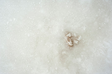 Closeup of the ice surface on a sunny day. Ice is rough with air bubbles and dents