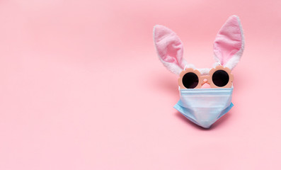 easter bunny in protective medical masks quarantine concept for easter holiday due to epidemic. Easter disease with preservation of positive. copy space, text. Bunny ears, sunglasses mask form face