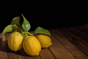 Lemons on wooden table with black background