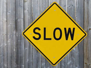 Slow sign on the wooden fence