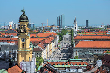 Fototapeta na wymiar Munich, Germany. View from tower of New Town Hall over the Ludwigstrasse avenue with tower of Theatinerkirche, tower of Ludwigskirche, Siegestor triumphal arch, and northern part of the city.