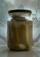 Pickled cucumbers in a glass jar.