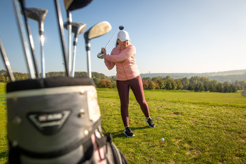 Female begginer golf player playing golf on the training ground, sport concept