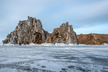 Fototapeta na wymiar Rock on the ice of winter Baikal on Olkhon island in Siberia. Beautiful nature: mountains, frozen lake, sky.