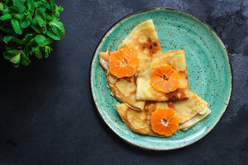 crepes with citrus, jam and berries (thin pancakes, mandarin, blueberry) menu concept. background. top view. copy space for text