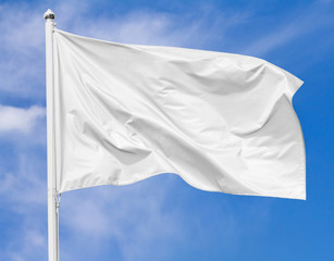 White flag waving in the wind on flagpole against the sky with clouds on sunny day, closeup