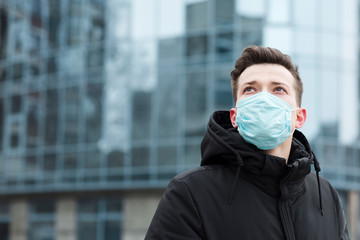 Man with medical mask posing in the city with copy space