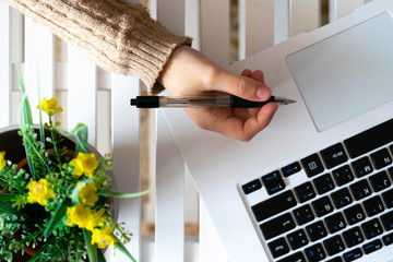 Hand picking up a black pen in the office.