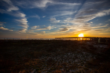 Panama city beach florida pier at sun down with beach silhouette and multi colored sky