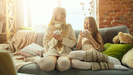 Home comfort. Happy loving family. Mother and daughter spending time together at home. Watching cinema, using laptop, laughting. Mother's day, celebration, weekend, holiday childhood concept.