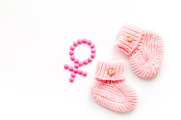 Pink booties for girl - pregnancy concept with Venus sign - on white background top-down copy space
