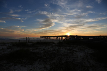 Obraz premium sundown at panama city beach pier with silhouette beach and pier and sunset clouds and sky