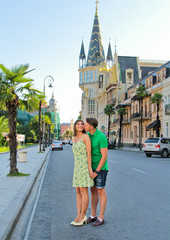 Obraz premium Man kissing and hug his woman. Romantic vacation. Young couple walking outdoors in summer Batumi city, Georgia.