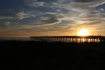 Fototapeta na wymiar sundown at panama city beach pier with silhouette beach and pier and sunset clouds and sky