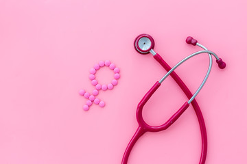 Women's Health issues. Medical concept with Venus sign and stethoscope on pink background top-down