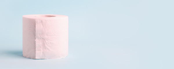 Toilet roll on blue background. Concept of lack of toilet paper in stores due to coronavirus, Covid-19, hygiene, panic. Copy space, deficit of sanitary set in supermarket