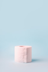 Toilet roll on blue background. Concept of lack of toilet paper in stores due to coronavirus, Covid-19, hygiene, panic. Copy space, deficit of sanitary set in supermarket