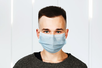 Sick guy looking at the camera with a surprised medical mask. Virus protection during influenza epidemic. corona virus