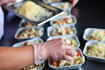 Food delivery. preparing food portions in containers. delivery service during quarantine covid-19. Chicken with vegetables and cheese. airline food. airline meals and snacks. takeaway selective focus