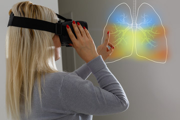 woman in virtual 3 d glasses looks at the lungs, coronavirus, pneumonia