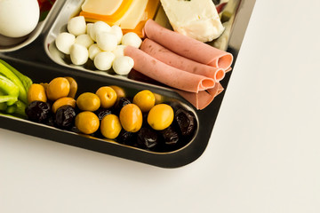 Traditional Turkish breakfast with salami, cheese, pepper, jam, egg, tomato, olives and fruits in a metal food tray 